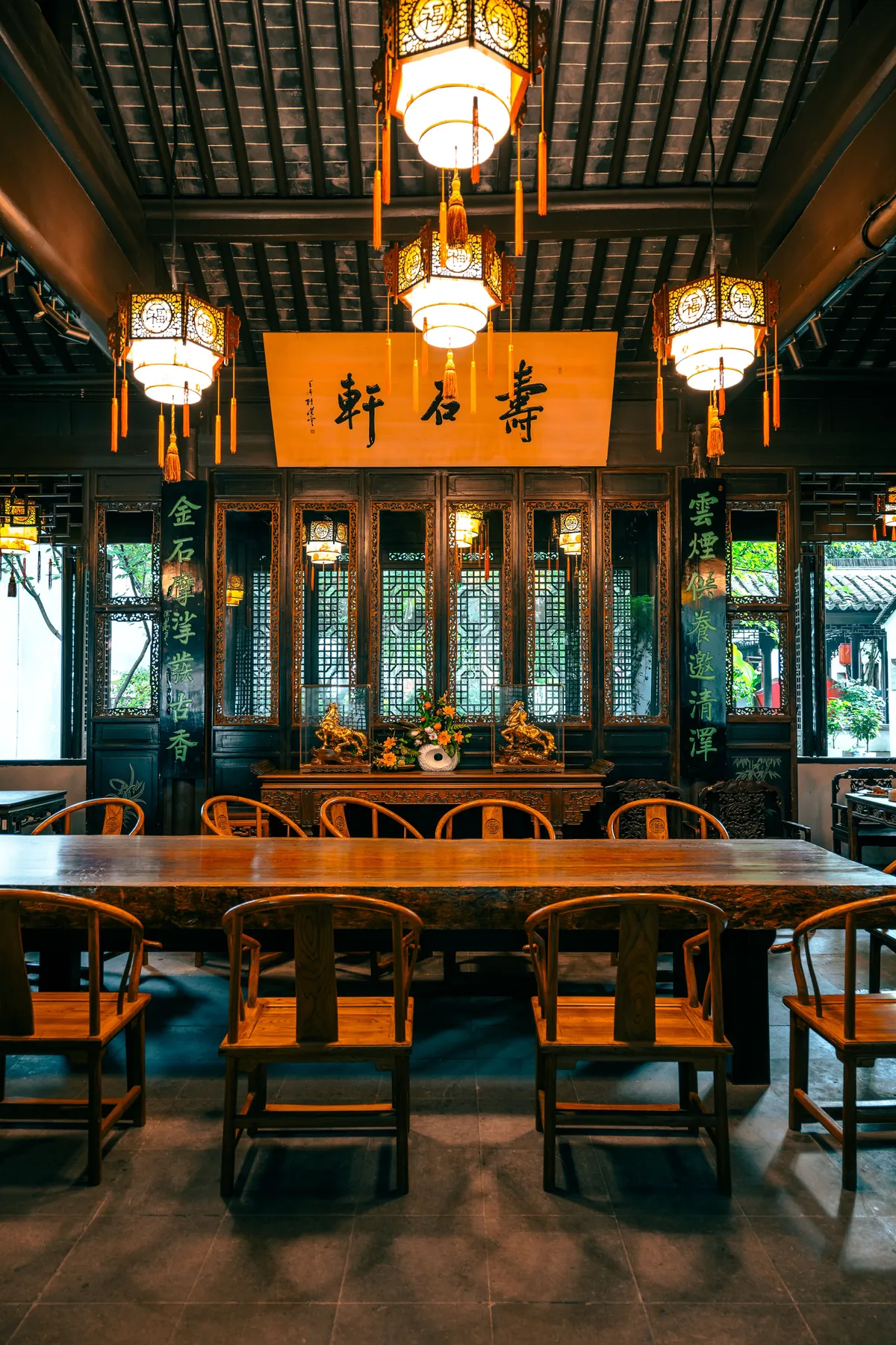 Tea house interior with hanging lanterns and a long wooden table
